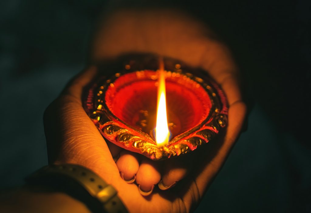 Une main d'homme et une main de femme, tenant ensemble une lampe à huile lors d'un rituel tantrique